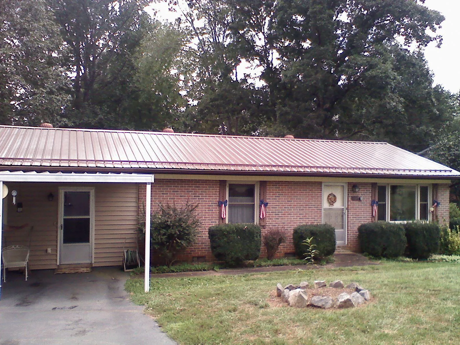 Bronze metal roof and carport on a brick ranch home — Roof Repair work by our crew in Deadwood
