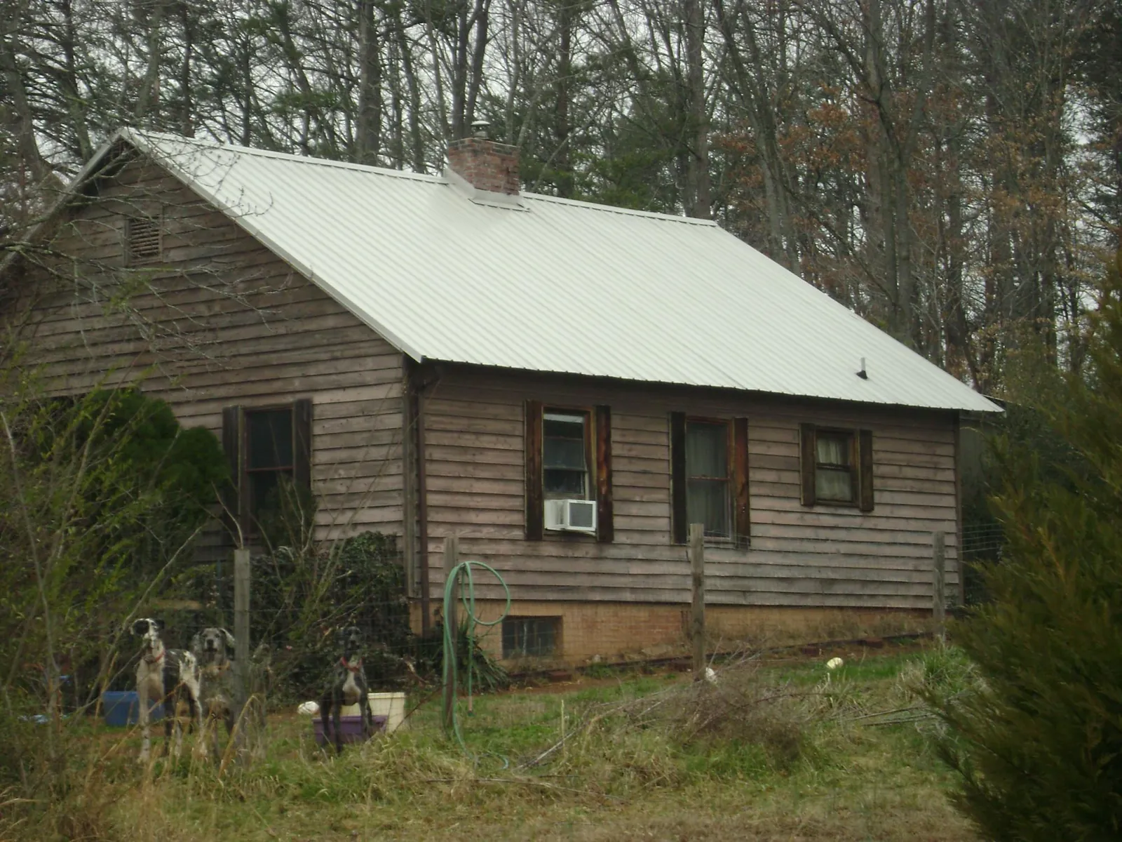 White metal roof on an old wood sided farmhouse, from a Metal Roof Installation job in Deadwood